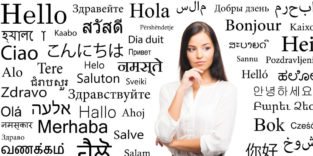 Frau vor einem Plakat, das "Hallo" in vielen verschiedenen Sprachen zeigt