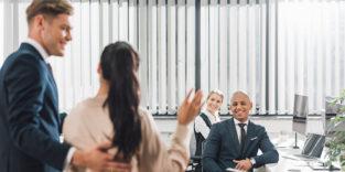 Frau winkt Arbeitskollegen zu