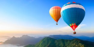 Urlaubsträume: Heißluftballons über Berggipfeln