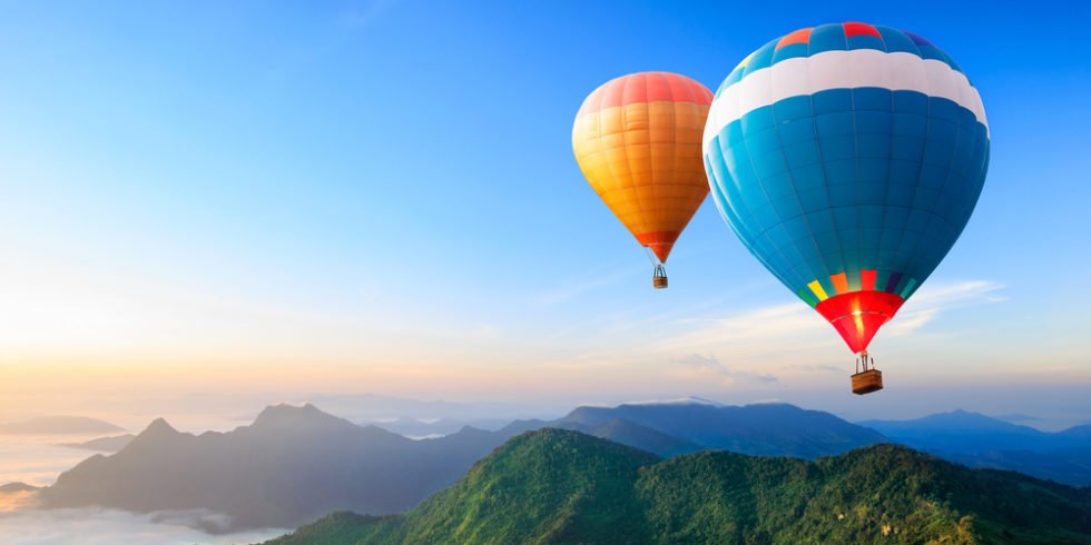 Urlaubsträume: Heißluftballons über Berggipfeln