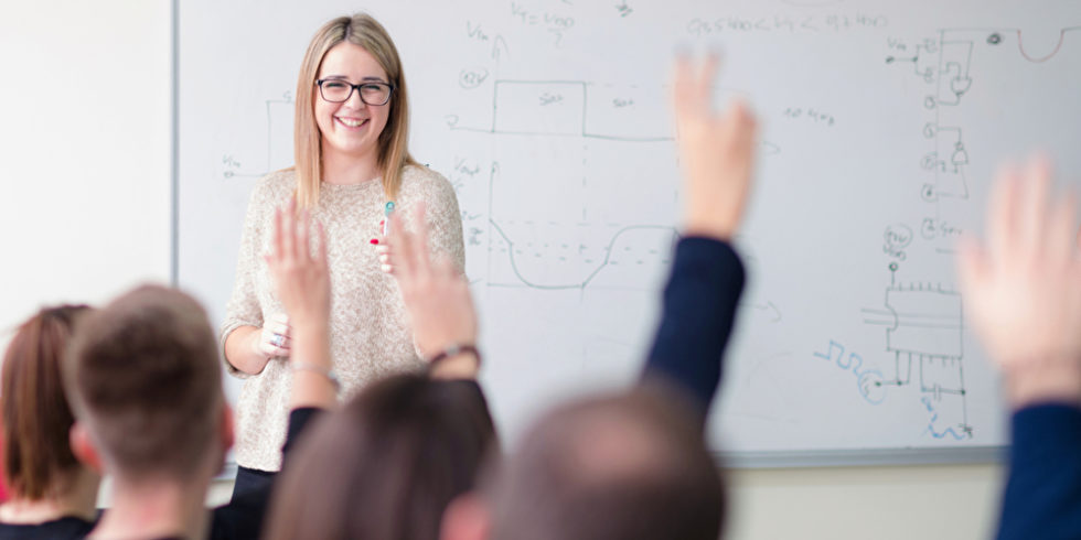 Lehrerin im Klassenraum technische Inhalte an der Tafel