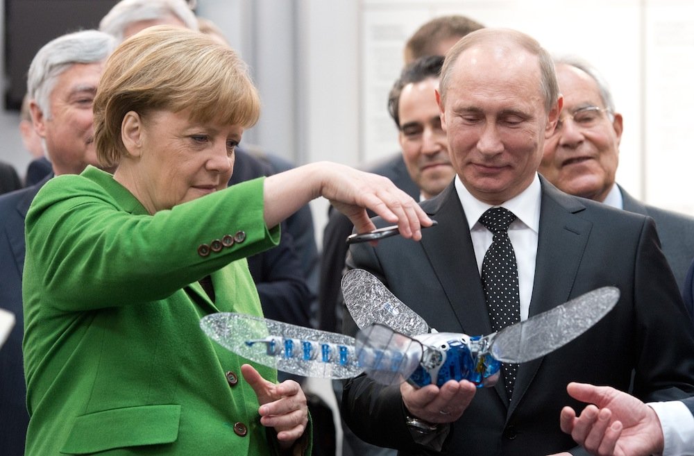 Bundeskanzlerin Angela Merkel und Russlands Staatspräsident Wladimir Putin staunen auf der Hannover Messe am Stand des Unternehmens Festo über eine künstliche Libelle.