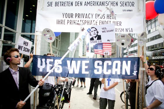 Mit Plakaten demonstrieren Teilnehmer am 18. Juni am Checkpoint Charlie in Berlin gegen das US-amerikanische Internet-Überwachungsprogramm der NSA Prism.