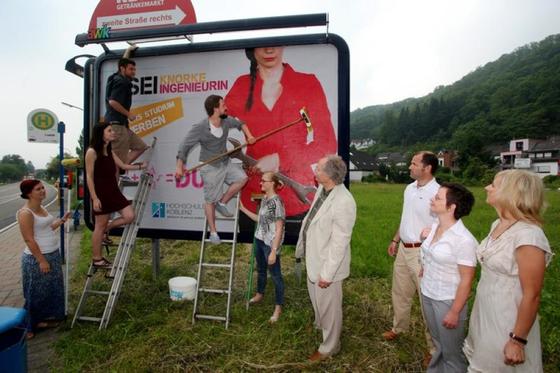 Fünf Marketing-Studierende bekleben die erste Großfläche mit ihrem Gewinnermotiv. 140 weitere Standorte in der Region Koblenz sollen in den kommenden Tagen folgen.