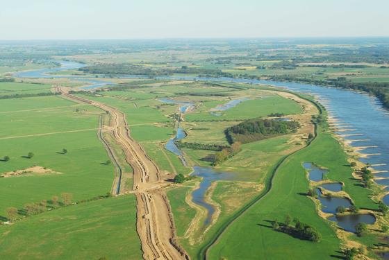 Deichrückverlegung: Die Luftaufnahme zeigt rechts die Elbe und den Altdeich, links die Neudeichbaustelle.