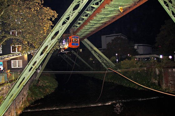 Ein etwa 100 Meter langes Stück der Schwebebahn-Stromschiene stürzte am 17.10.2013 in Wuppertal-Elberfeld zwischen den Haltestellen Kluse und Landgericht vom Gerüst. Die Stromschiene fiel auf mehrere Autos und blockierte die B7 sowie die Brücke Barmer Straße. Eine Schwebebahn, die zum Zeitpunkt des Unfalls in Richtung Oberbarmen unterwegs war, wurde kurz vor der Brücke Barmer Straße unsanft gestoppt. Die etwa 100 Fahrgäste mussten von der Feuerwehr mit einer Drehleiter in Sicherheit gebracht werden. Der Schwebebahnverkehr wird voraussichtlich noch bis Anfang nächster Woche ruhen. 