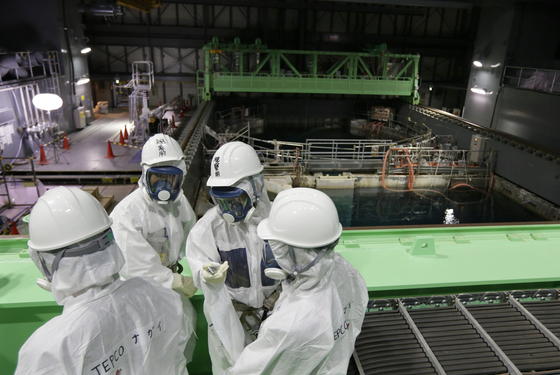 Ingenieure vor dem Abklingbecken für Brennstäbe im Reaktor 4 des Atomkraftwerkes Fukushima: Die Bergung der 1300 Brennelemente wurde wegen technischer Probleme verschoben.