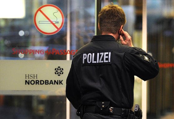 Ein Polizist geht am 19. November 2013 in Hamburg in ein Gebäude der HSH Nordbank. Die Geschäftsräume der Bank wurden wegen des Verdachts der Geldwäsche durchsucht. 