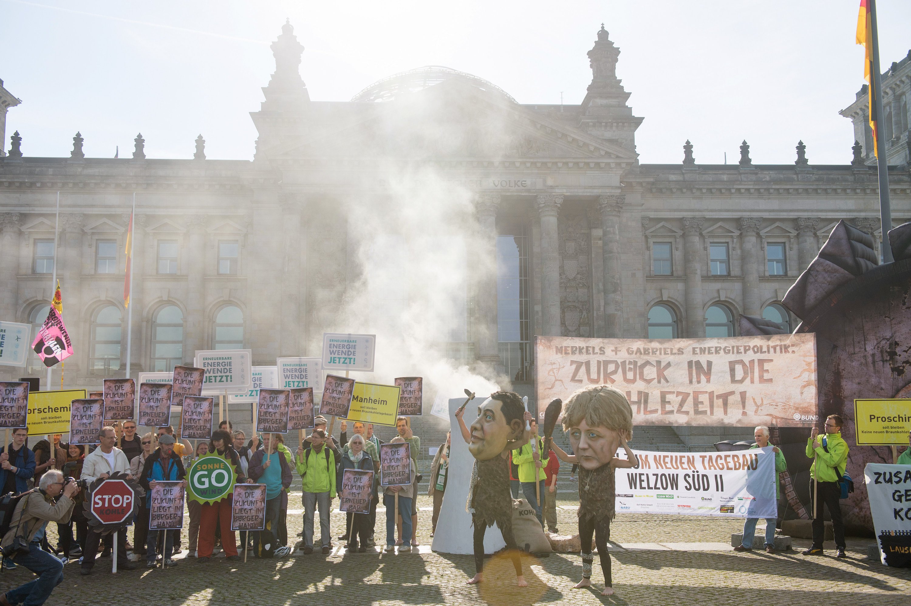 Aktivisten protestieren am 27. Juni 2014 in Berlin gegen die Verabschiedung des Erneuerbare-Energien-Gesetzes durch den Bundestag. Mit Rauch, der aus einem gebastelten Kraftwerksturm aufsteigt, wollen sie dabei auf die umweltschädlichen Emissionen aus Kohlekraftwerken hinweisen. 