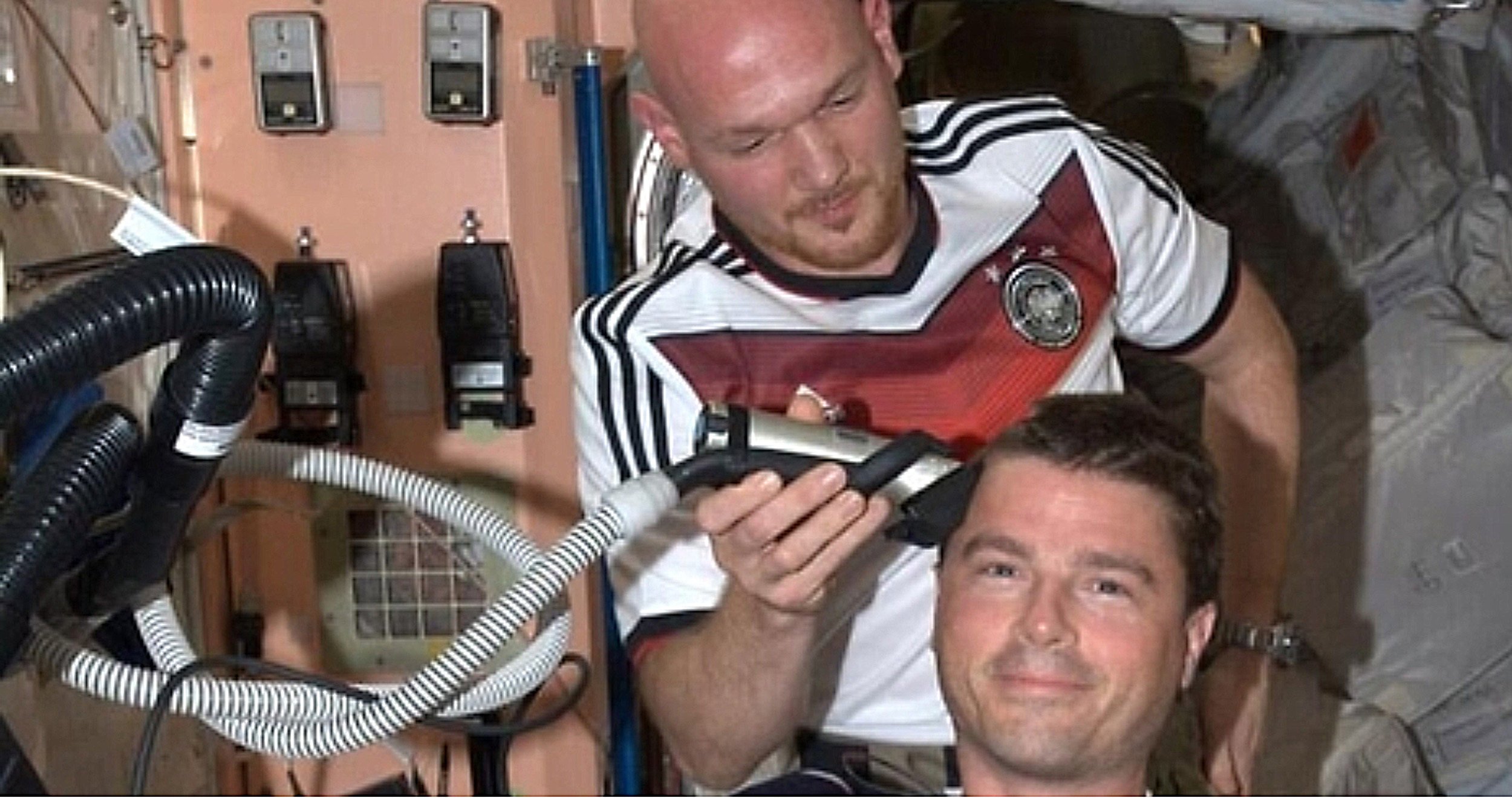 Im Trikot der deutschen Fußball-Nationalmannschaft rasiert Alexander Gerst an Bord der Internationalen Raumstation ISS seinem US-Kollegen Reid Wiseman das Kopfhaar ab. Anlass war eine Wette, nach der sich bei einem WM-Sieg der deutschen Fußballer über die USA die beiden US-Astronauten Wiseman und Swanson eine Glatze verpassen lassen würden. Bei einem Sieg der USA hätte sich Gerst die US-Flagge auf den kahlen Kopf malen lassen. 