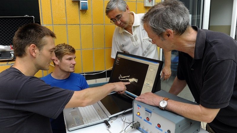 Der Jenaer Sportwissenschaftler Dr. Stefan Hochstein zeigt seinen Kollegen am Computer die Visualisierung der Strömung, die den Schwimmer umgibt. 