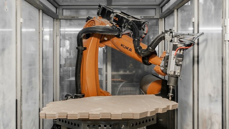 Ein Roboter bringt die Holzplatten in Form – mit einer siebenachsigen Fräsmaschine auf Basis der digitalen Konstruktionszeichnung. Die Maßtoleranz der Bauteile betrug gerade einmal 0,86 Millimeter.