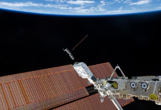 Die Internationale Raumstation ISS setzt derzeit die Minisatelliten von Planet Labs aus (Pfeil). Diese enthalten Kameras, die laufend Bilder der Erde über das Internet anbieten sollen. Jetzt sind zwei Satelliten "aus Versehen" ausgesetzt worden und kreisen auf einer falschen Umlaufbahn.