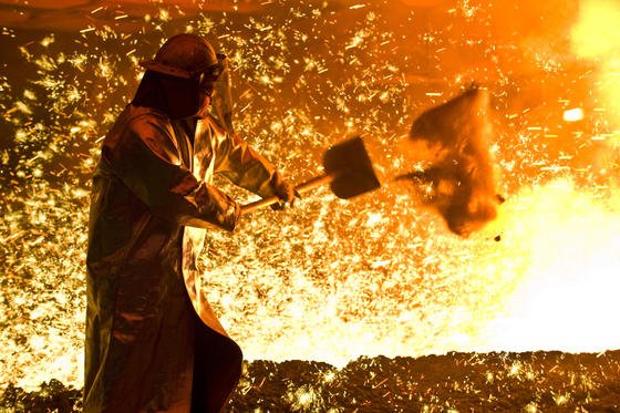 Ein Arbeiter in Schutzkleidung vor einem angestochenen Hochofen. Mit dem neuen Spektrometer soll sich die spätere Stahlqualität noch genauer prüfen lassen. 