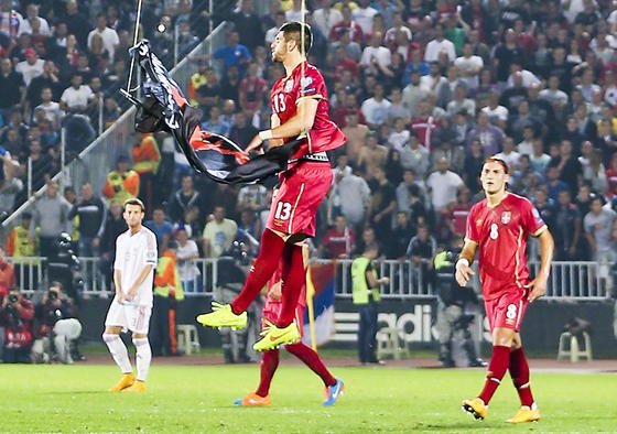 Der serbische Spieler Stefan Mitrovic, Innenverteidiger beim deutschen Bundesligisten SC Freiburg, bekommt die albanische Fahne zu fassen und reißt sie zu Boden. 