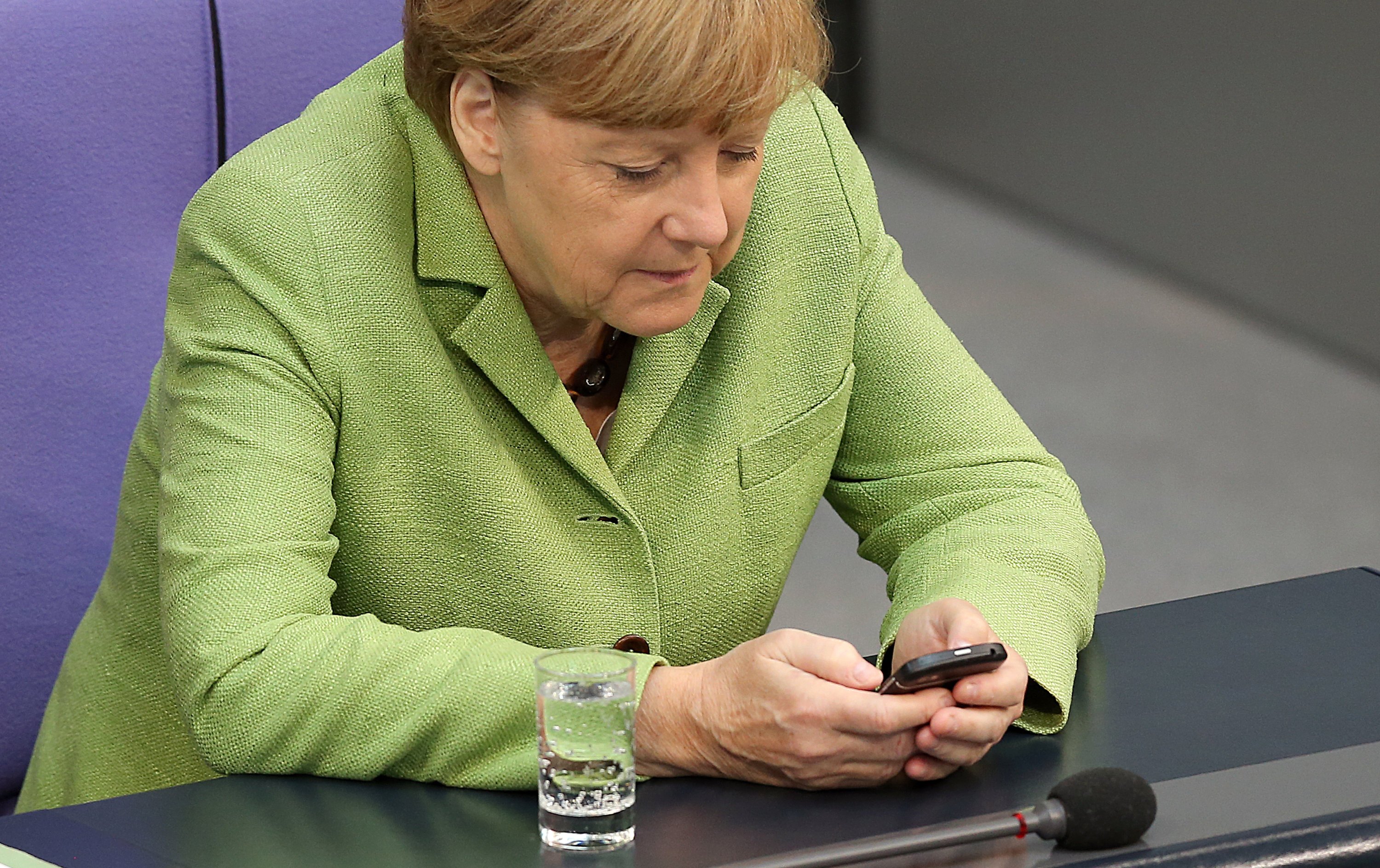 Auch Bundeskanzlerin Angela Merkel nimmt bei der Benutzung ihres Smartphones eine ungesunde Haltung ein. 