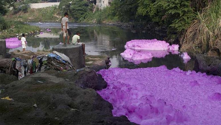 Die Fabriken, in denen Adidas, Nike und Puma in Asien produzieren lassen, leiten nach Angaben von Greenpeace giftige Chemikalien in die Gewässer. Im Bild der Fluss Tullahan auf den Philippinen mit lila Schaumwolken.