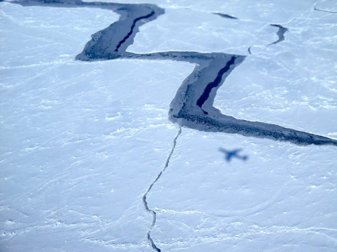 Eisschichten auf dem Weddell-Meer in der Antarktis: Von unten nach oben strömendes, leicht erwärmtes Tiefenwasser beschleunigt die Eisschmelze in der Antarktis. Auf dem Bild auch deutlich zu sehen ist der Schatten der  DC-8 der NASA, mit der das Bild aufgenommen wurde.