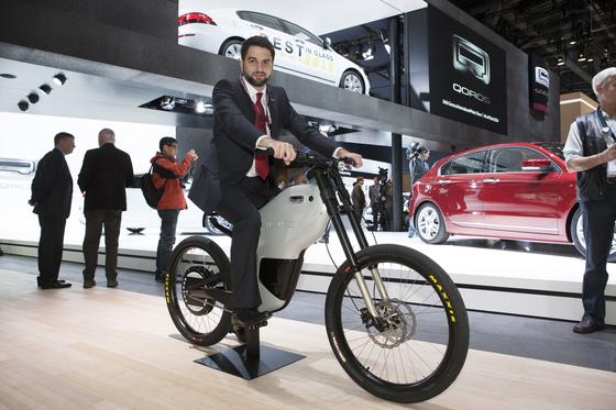 Vorstellung des eBIQUE auf dem Genfer Autosalon 2014. An der Entwicklung war die Marke Greyp von Rimac Automobili maßgeblich beteiligt. Rimac-Designer Adriano Mudri sitzt auch gut auf dem Qoros-Roller.