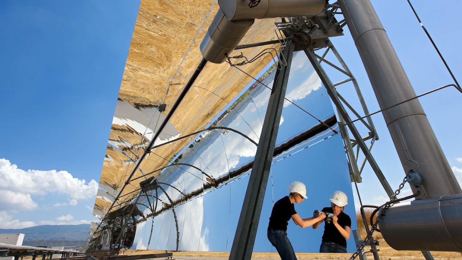 Parabolrinnenkollektoren fokussieren die Sonne linienförmig und lenken die Strahlen auf ein Receiverrohr. Dort erhitzen sie ein Wärmeträgermedium, das Dampf erzeugt, der wie in einem konventionellen Kraftwerk eine Turbine antreibt.          