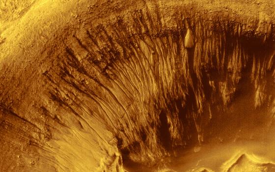 Rinnen in den Wänden eines Mars-Kraters: Möglicherweise stammen sie von Trockeneis-Platten, die den Boden zeitweise destabilisieren.  