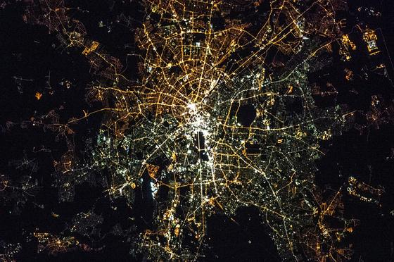 Berlin bei Nacht, fotografiert von der ISS: Im Westteil der Stadt leuchten vor allem weiße Quecksilber- oder auch LED-Lampen. Im Osten bestehen viele Straßenbeleuchtungen noch aus gelblichen Natriumdampflampen.