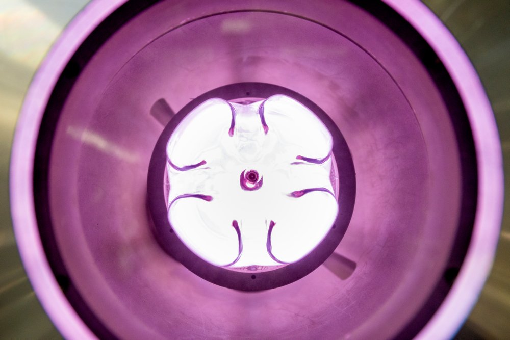 Ein Argon-Plasma in einer PET-Flasche – hier ist nur der Flaschenboden sichtbar. Das Plasma „reinigt“ und aktiviert die Flaschenoberfläche von innen.