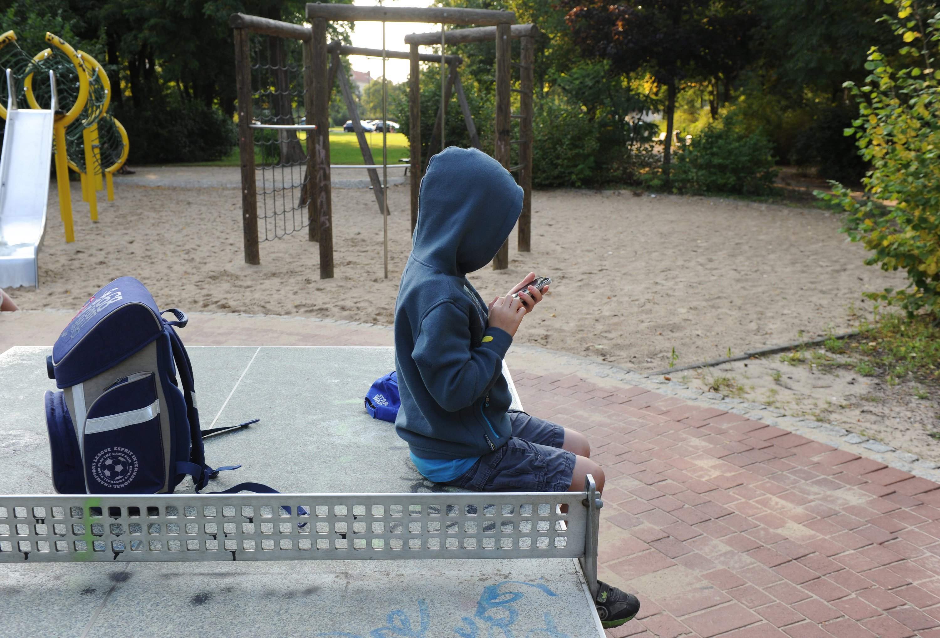 Kind mit Smartphone auf einem Kinderspielplatz in Berlin: Das Telefon ist längst zum unverzichtbaren Begleiter auch von Kindern geworden. Selbst kurz vor dem Schlafen wird das Gerät benutzt. Die Folge: Manche Kinder schlafen nur noch fünf Stunden pro Nacht.