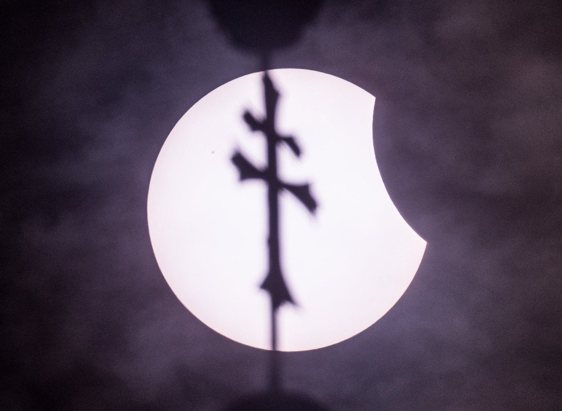 Mystisch: Das Foto zeigt die Sonnenfinsternis am 20. März 2015 in Brandenburg am Himmel hinter dem Kreuz an der Turmspitze vom Kloster in Neuzelle.