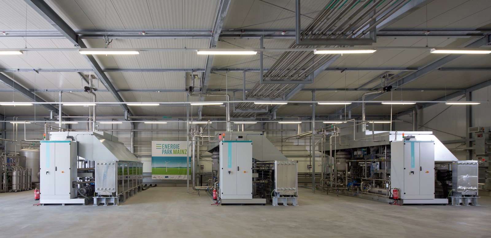 In der Elektrolysehalle erzeugt ein Wasserstoff-Elektrolysesystem von Siemens Wasserstoff aus Stromüberschüssen. Die PEM-Druckelektrolyse mit bis zu 6 MW Stromaufnahme ist weltweit die größte dieser Art. Der Energiepark hat damit die richtige Größe, um das Stromangebot kleinerer Windparks zu verstetigen.