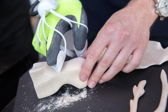 Mit dem Handschuh Happaratus kann man harte Materialien wie Stein und Holz bearbeiten. An den Fingerkuppen sind kleine Polster mit Schleifpapier montiert, die von einem kleinen Elektromotor bewegt werden.