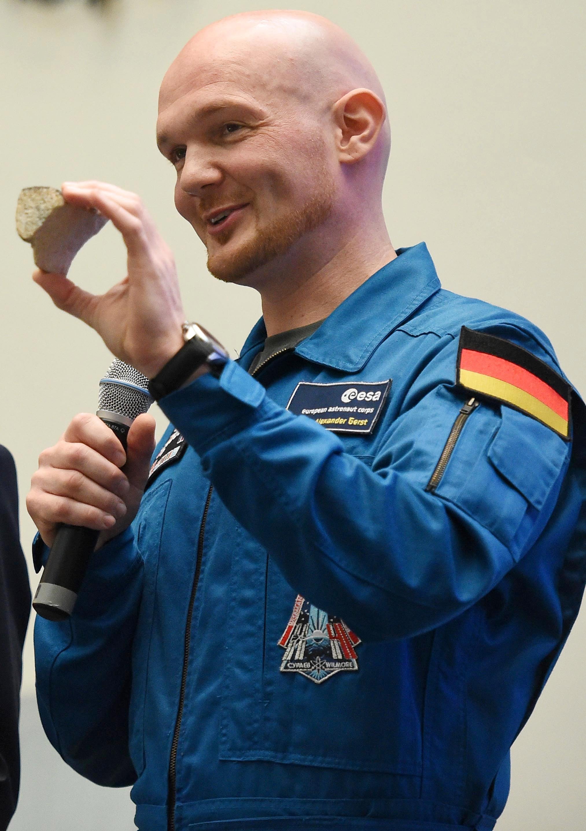 ESA-Astronaut Alexander Gerst mit dem weit gereisten Stück Sandstein aus der Fassade des Kölner Doms in der Hand. 