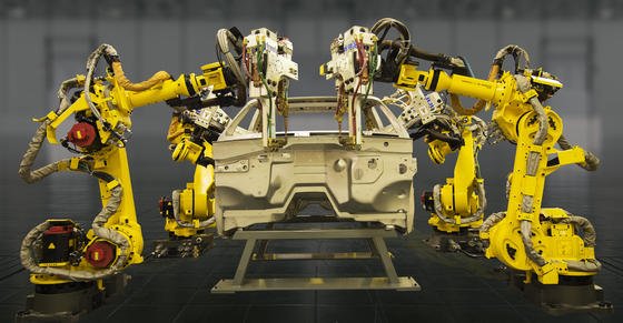 Roboterarme von Fanuc arbeiten an einer Autokarosserie. Künstliche Intelligenz soll sie selbstständig lernen und im Team arbeiten lassen. 