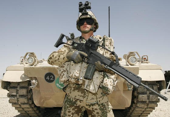 Ein Bundeswehrsoldat der schnellen Eingreiftruppe 2008 im afghanischen Feldlager Marmal bei Masar-i-Scharif mit einem Sturmgewehr G36 vor einem Schützenpanzer Marder 1 A5 M. Weil das Gewehr bei Hitze nicht genau genug schießt, wird es ausgemustert. 