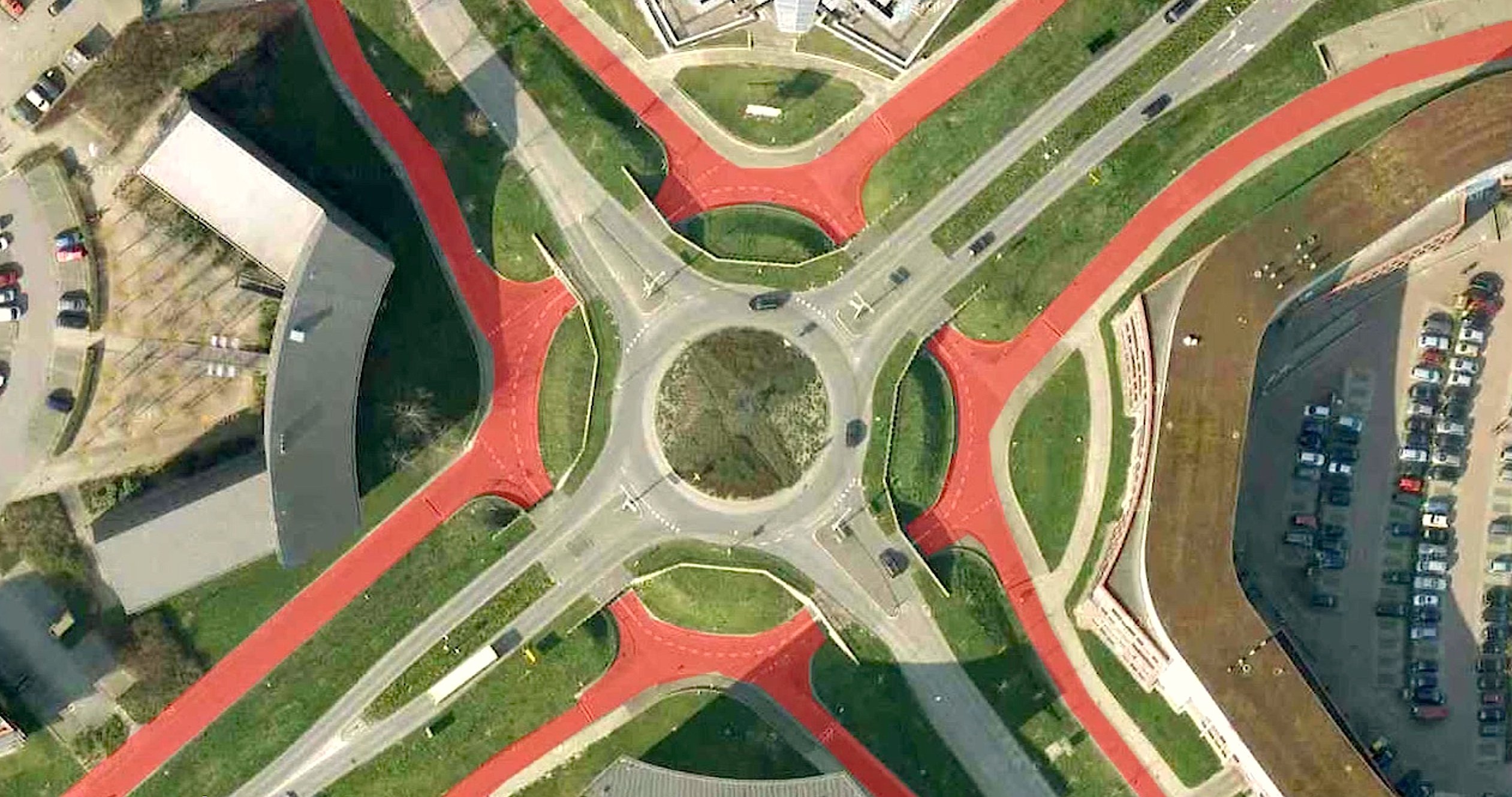 Kreuzungsfreier Kreisverkehr für Radfahrer im niederländischen Houten: Dort können Radfahrer auf den rot eingefärbten Flächen ohne anzuhalten eine wichtige Autokreuzung passieren. Und damit es der Radverkehr ganz einfach hat, ist der Autokreisel (grau) erhöht angelegt. Dadurch müssen die Radfahrer nur einen Meter nach unten fahren, um die Fahrbahnen zu unterqueren.