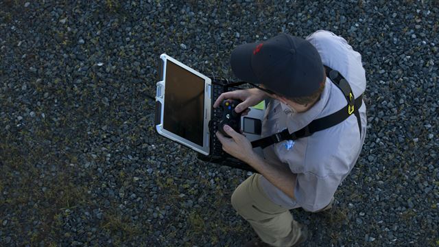 Roboter-Hund Spot hört auf Radiosignale, die von einem Laptop und einem Steuerungsgerät kommen, ähnlich wie bei einer Spielkonsole.