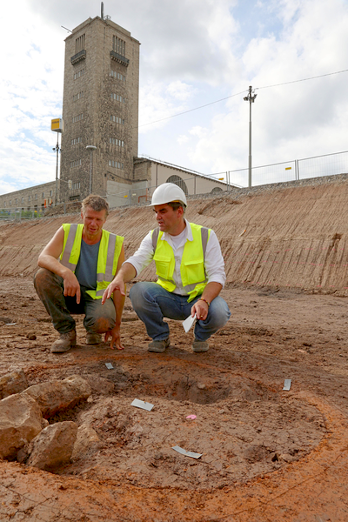 Archäologen auf der Baustelle für Stuttgart 21: Grabungsleiter Dr. Martin Thoma (l.) und Gebietskonservator Dr. Andreas Thiel knien vor einem runden Töpferofen.