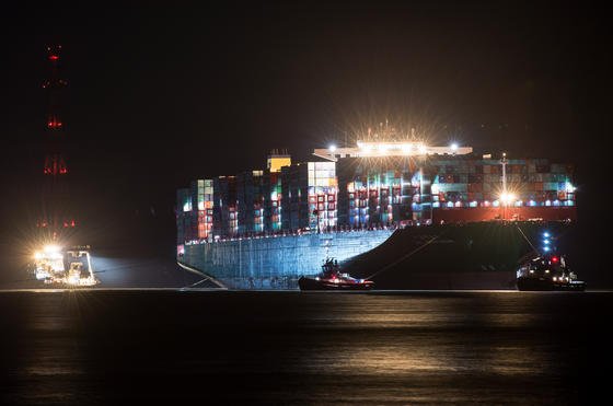 Mehrere Schlepper haben am 9. Februar 2016 an dem Containerfrachter "CSCL Indian Ocean" der Reederei China Shipping Lines festgemacht und warten auf den günstigsten Zeitpunkt, um den Riesen wieder in das Fahrwasser der Elbe vor Grünendeich bei Stade (Niedersachsen) zu ziehen. Das 400 Meter lange und 59 Meter breite Schiff war bereits am 3. Februar nach einem Schaden an der Ruderanlage aus der Fahrrinne gedriftet und auf Grund gelaufen. 