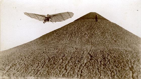 Das Bild zeigt Otto Lilienthal beim Flug vom Fliegeberg in Berlin, den er eigens aufschütten ließ und der somit einer der ersten künstlichen Flugplätze ist. Gemacht hat die Aufnahme der Pionier der Fototechnik Ottomar Anschütz.