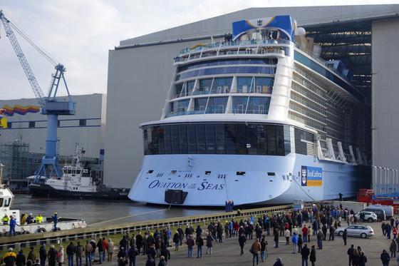 Wahnsinn: Da kommt sie langsam aus ihrer Geburtsstätte heraus, die 347,75 m lange Ovation of the Seas. Verschwindend klein wirken daneben die staunenden Schaulustigen. 