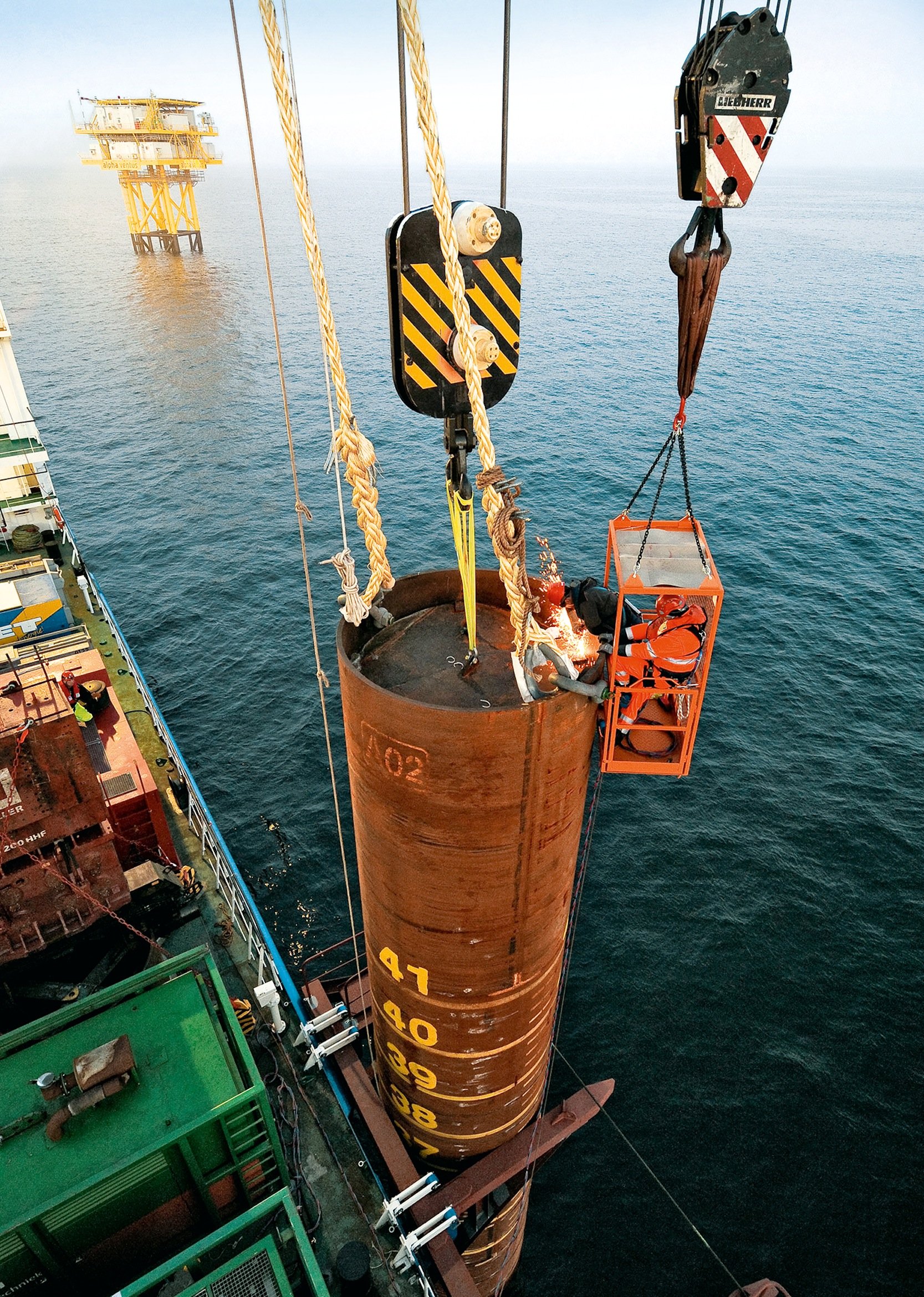 Für die Fundamente von Offshore-Anlagen werden jeweils drei verschweißte Stahlrohre zu einem Tripod zusammengesetzt und auf dem Meeresboden verankert. Darauf steht dann die eigentliche Windkraftanlage. Im Bild wird eines der Stahlrohre eines Tripods im Meer versenkt. Diese Rohre sind konventionell verschweißt und unter Wasser den Belastungen des Salzwassers ausgesetzt. 