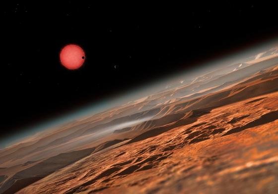 Im Sternbild Wassermann haben Forscher den Planeten Trappist-1 entdeckt. Die künstlerische Illustration zeigt Trappist-1 im Hintergrund, im Vordergrund zu sehen die Oberfläche eines der drei erdähnlichen Planeten, die den Trappist-1 umkreisen.