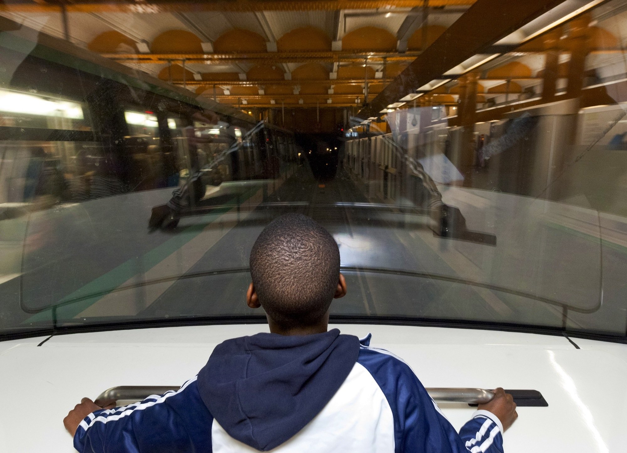Ein Junge in einer fahrerlosen Metro genau dort, wo sonst der Fahrer sitzt: Die Pariser Metro betreibt zwei Linien mit fahrerlosen Zügen. In der Spitze ermöglicht die Technik einen 85-Sekunden-Takt, der mit gewöhnlichen Zügen nicht zu schaffen ist.
