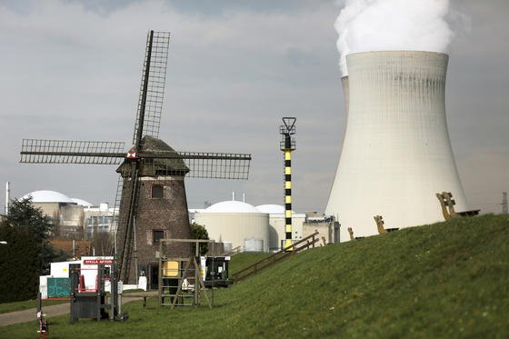 Dampf steigt hinter einer Windmühle bei Antwerpen (Belgien) aus den Kühltürmen des Atomkraftwerks Doel. Während Deutschland 2022 Akw-frei sein will, sehen die Energiepläne der EU-Kommission den Ausbau der Kernkraft vor. 