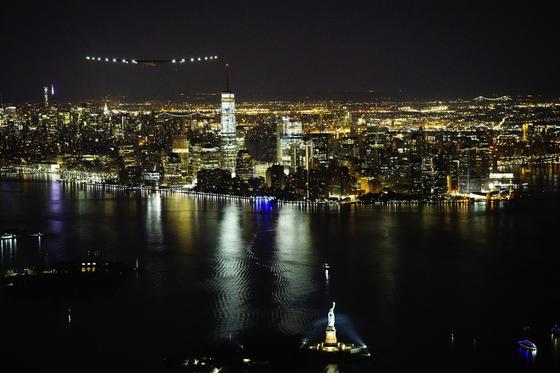 Das Solarflugzeug Solar Impulse 2 beim Flug über New York mit Kurs auf die Freiheitsstatue. 