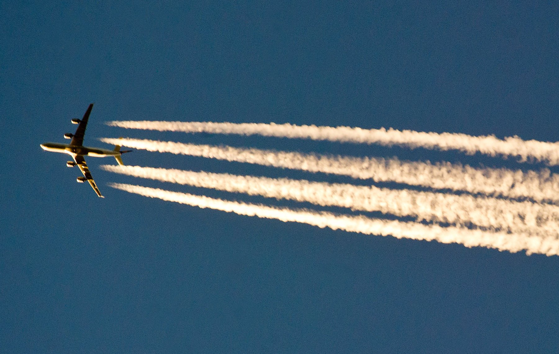 Ein Flugzeug hinterlässt Kondensstreifen am Himmel. Sie entstehen, wenn heiße, wasserdampfhaltige Triebwerksabgase von Luftfahrzeugen auf kalte Luft treffen. 