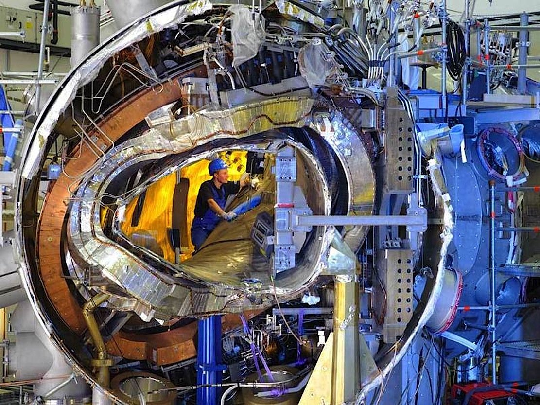 Im November 2011 ließ sich in das Innere von Wendelstein 7-X noch hineinsehen. Von innen nach außen sieht man das Plasmagefäß, eine der verwundenen Stellaratorspulen, eine ebene Spule, die Stützstruktur und das Außengefäß zusammen mit zahlreichen Kühlleitungen und Stromzuführungen.