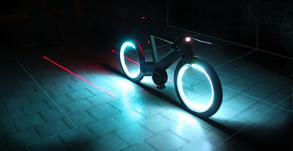 Cyclotron Bike im Dunkeln mit roten Laserstreifen rechts und links um das Hinterrad