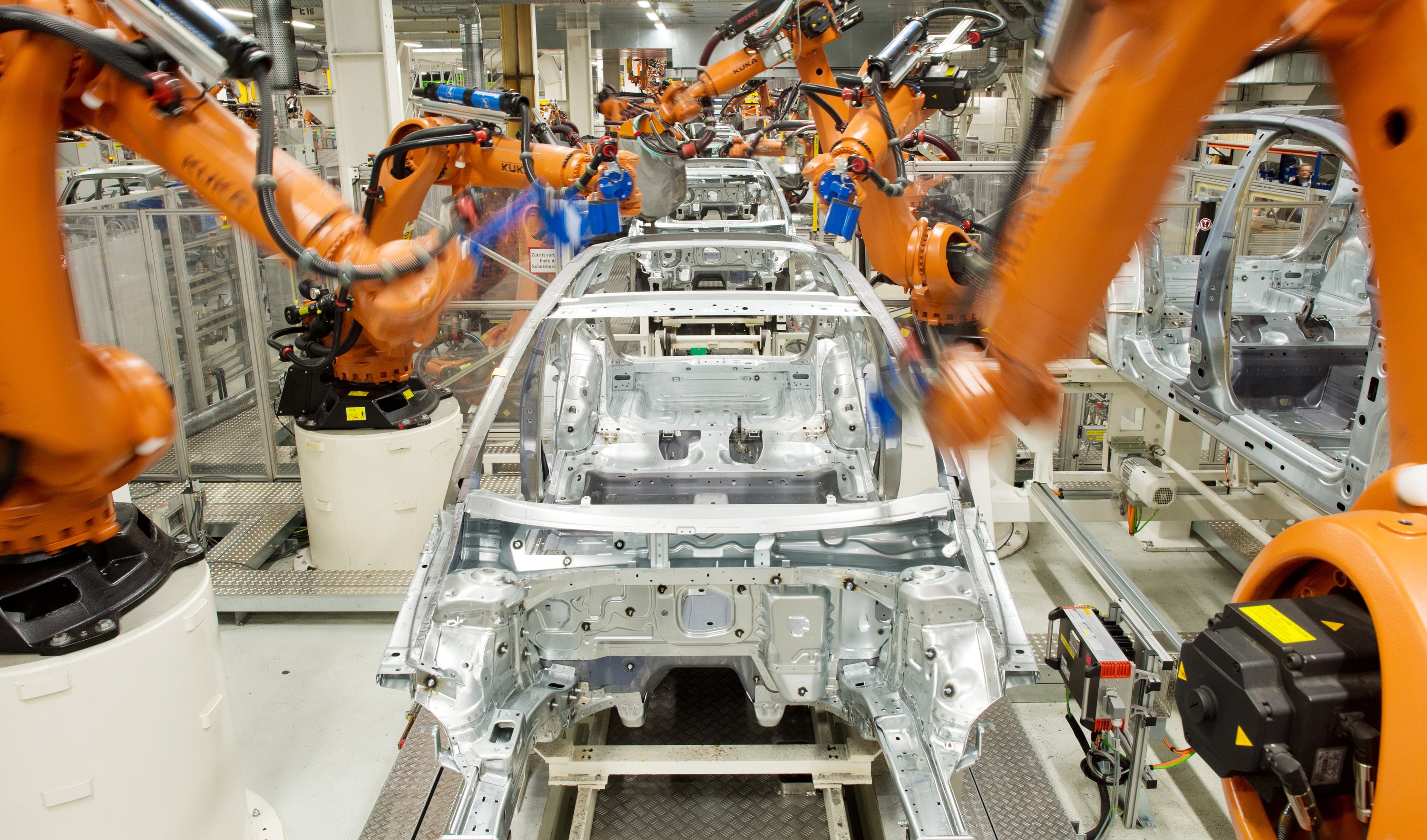 Roboter der Firma Kuka arbeiten im Februar 2013 im VW-Werk in Wolfsburg an der Produktionsstraße für den VW Golf VII. 