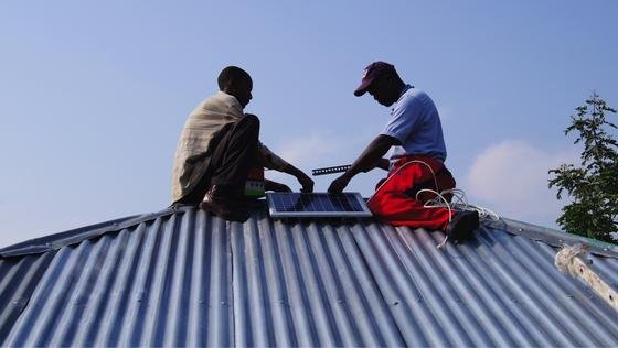 Solar-Moskitofalle: Montage der Solarpanel an einem Hausdach auf der Insel Rusinga in Kenya.